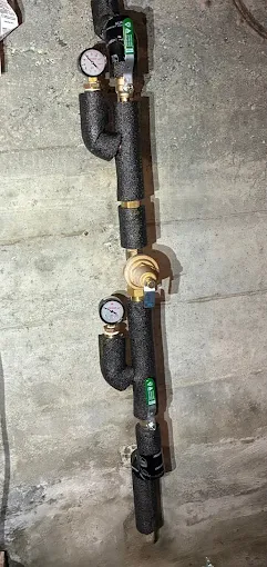 Insulated main water supply line with shutoff valves and pressure gauges